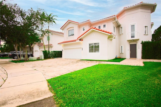 mediterranean / spanish-style home with a garage and a front lawn