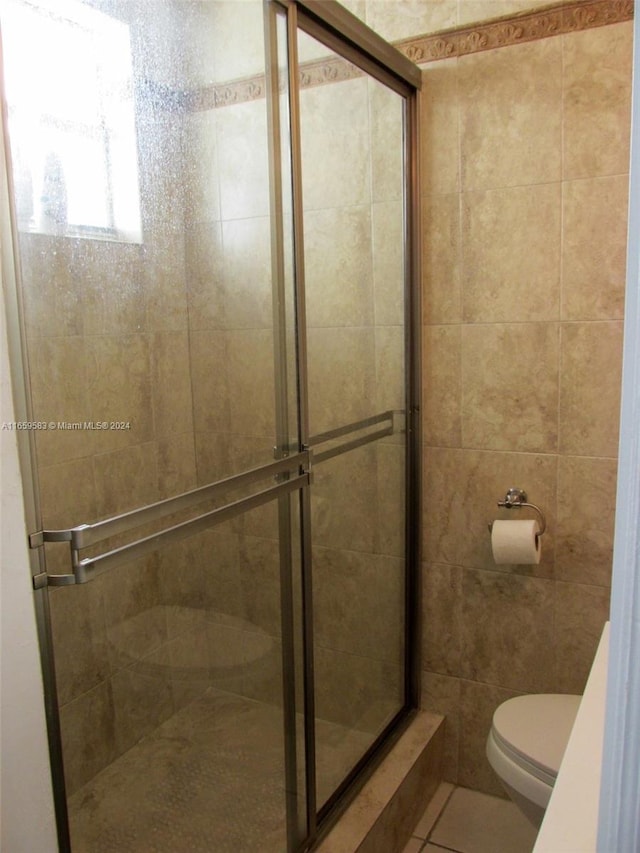 bathroom featuring toilet, tile patterned floors, and walk in shower