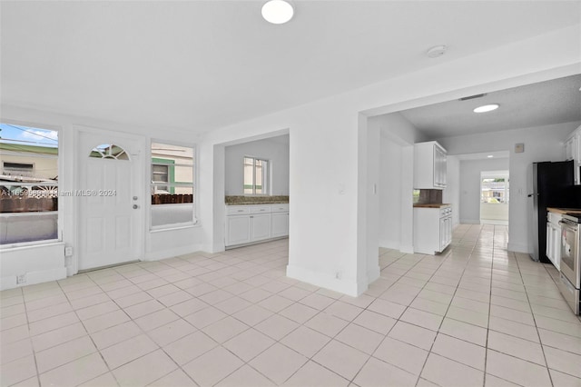 unfurnished living room featuring plenty of natural light and light tile patterned floors