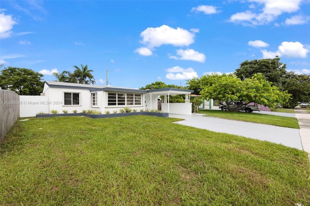 view of front of property with a front yard and a carport