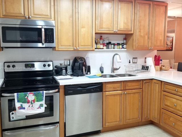 kitchen with light tile patterned floors, stainless steel appliances, and sink