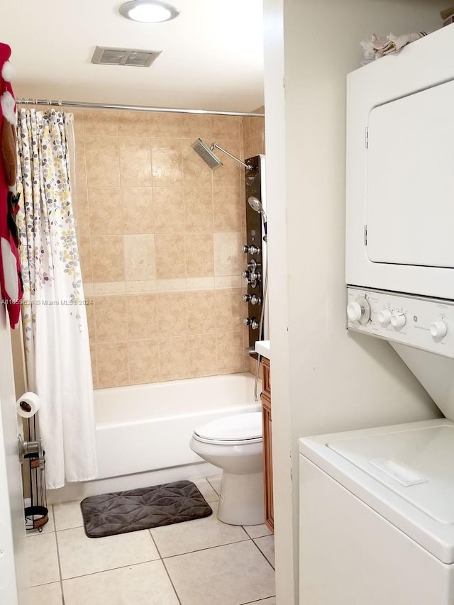 interior space featuring tile patterned floors, toilet, shower / bath combo with shower curtain, and stacked washing maching and dryer