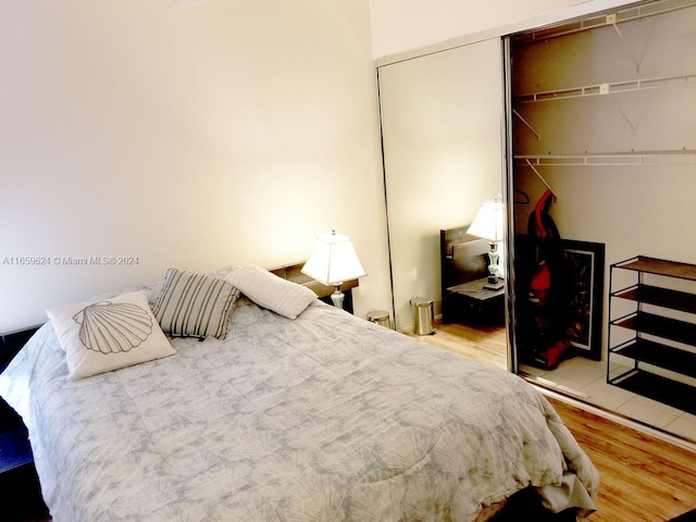 bedroom with wood-type flooring and a closet