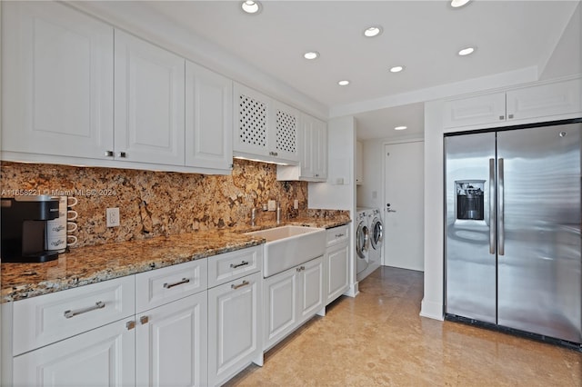 2200 S Ocean Ln Unit 702, Fort Lauderdale, FL 33316 - kitchen featuring stainless steel fridge with ice dispenser, washing machine and dryer, light stone counters, white cabinetry, and a sink