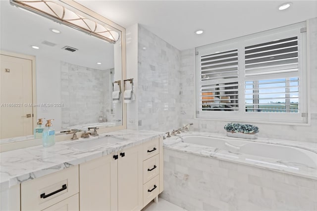 bathroom with tiled tub and vanity