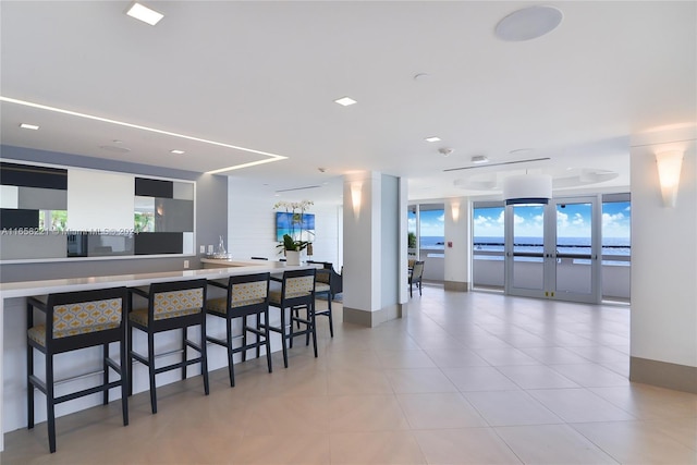 2200 S Ocean Ln Unit 702, Fort Lauderdale, FL 33316 - kitchen featuring light tile patterned floors, a healthy amount of sunlight, and a breakfast bar