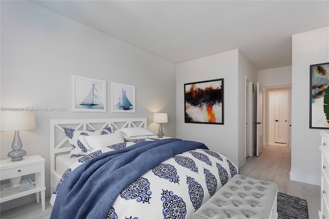 bedroom featuring a textured ceiling and light wood-type flooring