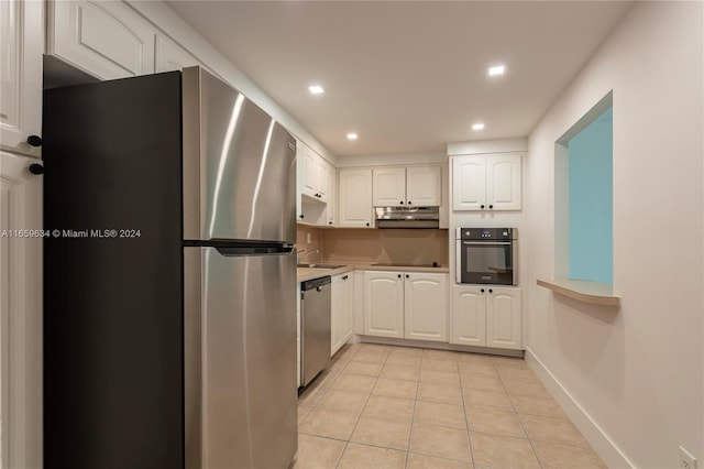 kitchen featuring stainless steel appliances, sink, light tile patterned floors, and white cabinetry