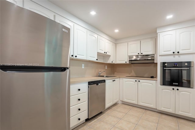 kitchen featuring light tile patterned floors, white cabinetry, stainless steel appliances, and sink