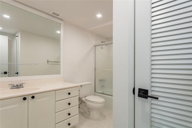 full bathroom featuring vanity, toilet, tile patterned flooring, and bath / shower combo with glass door