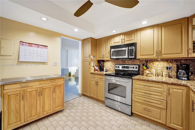 kitchen with appliances with stainless steel finishes, ceiling fan, and decorative backsplash