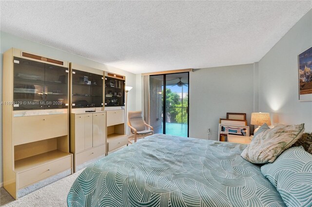 carpeted bedroom featuring access to outside and a textured ceiling