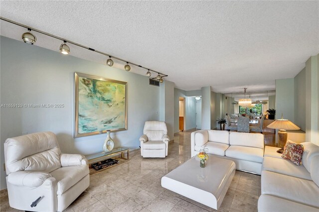 living room with rail lighting and a textured ceiling