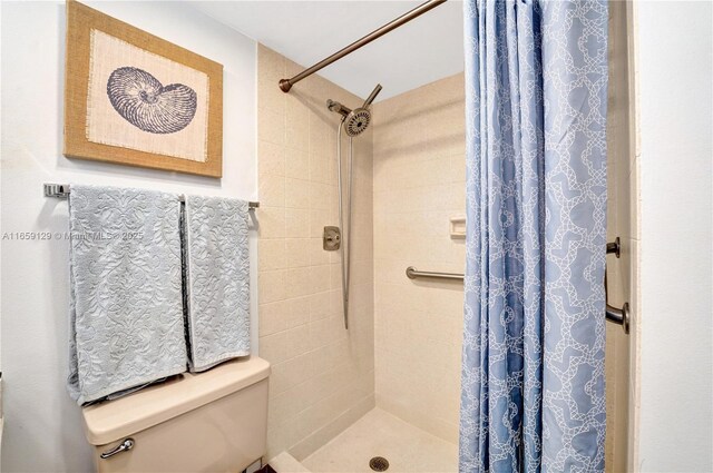 bathroom with curtained shower and toilet