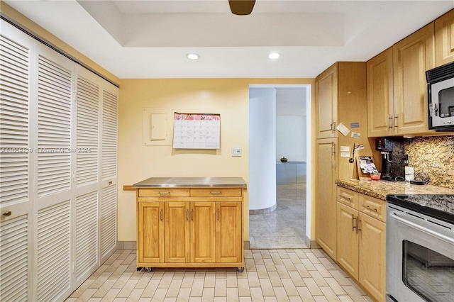 kitchen featuring tasteful backsplash, light tile patterned floors, and stainless steel range