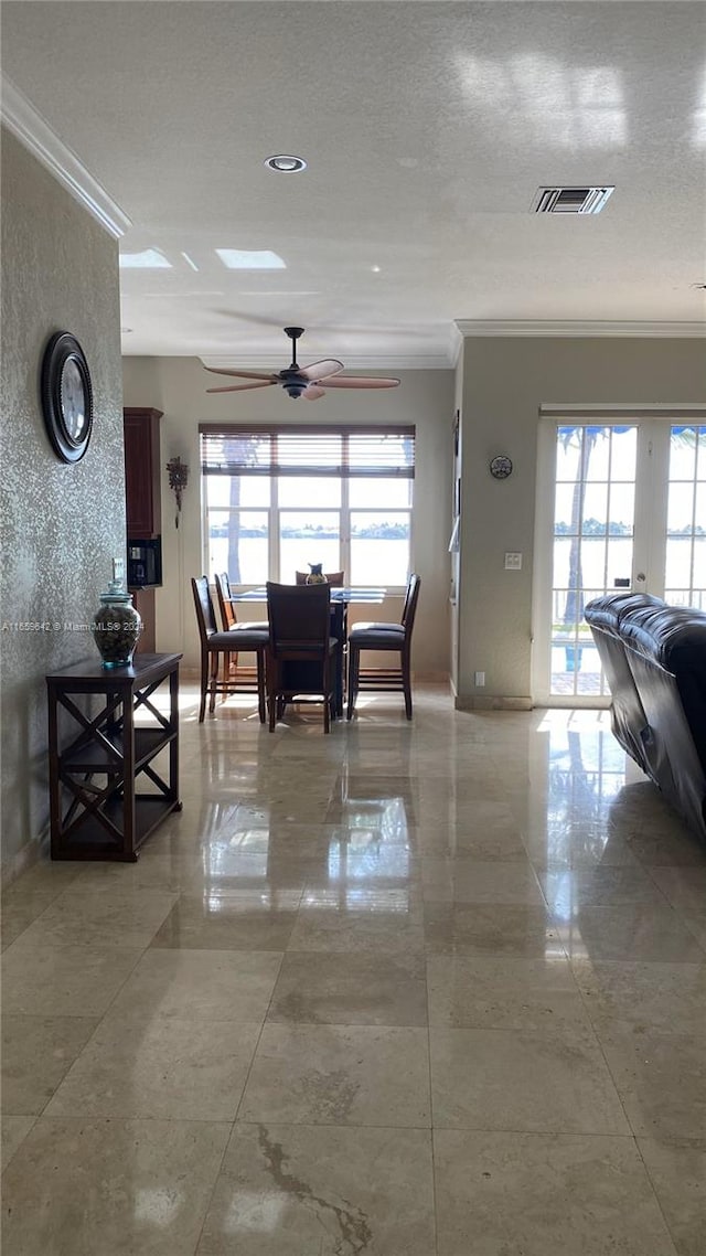 dining space with ornamental molding and ceiling fan