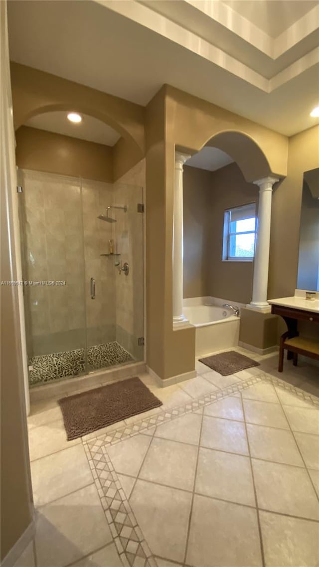 bathroom with ornate columns, separate shower and tub, and tile patterned floors