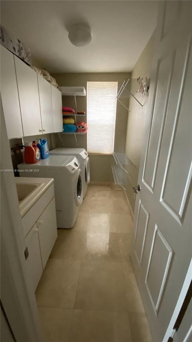 clothes washing area featuring washing machine and dryer and cabinets