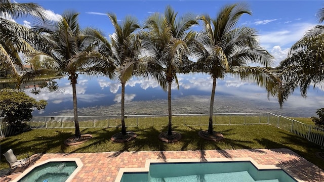 view of pool featuring a lawn, a water and mountain view, a patio area, and a hot tub