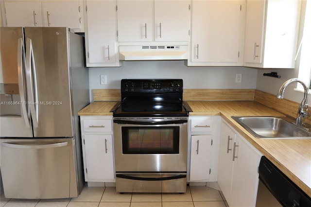 kitchen featuring ventilation hood, white cabinets, light tile patterned floors, stainless steel appliances, and sink