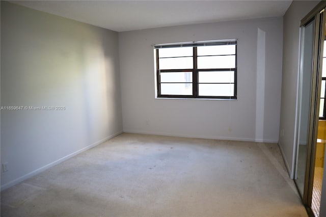 empty room with light carpet and baseboards