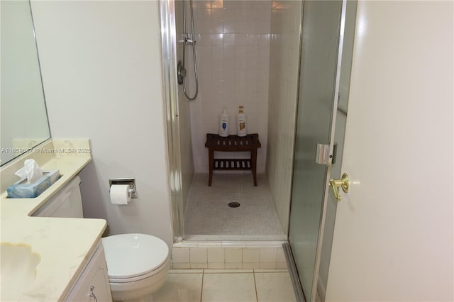 bathroom with toilet, tile patterned flooring, a shower stall, and vanity