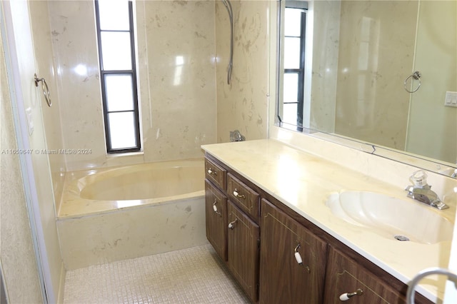 bathroom featuring a bathing tub, tile patterned flooring, plenty of natural light, and vanity