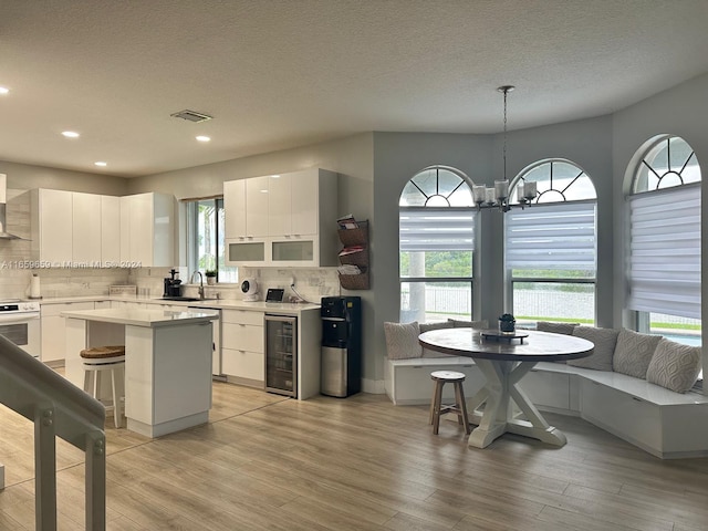 kitchen with white cabinets, pendant lighting, a center island, and plenty of natural light