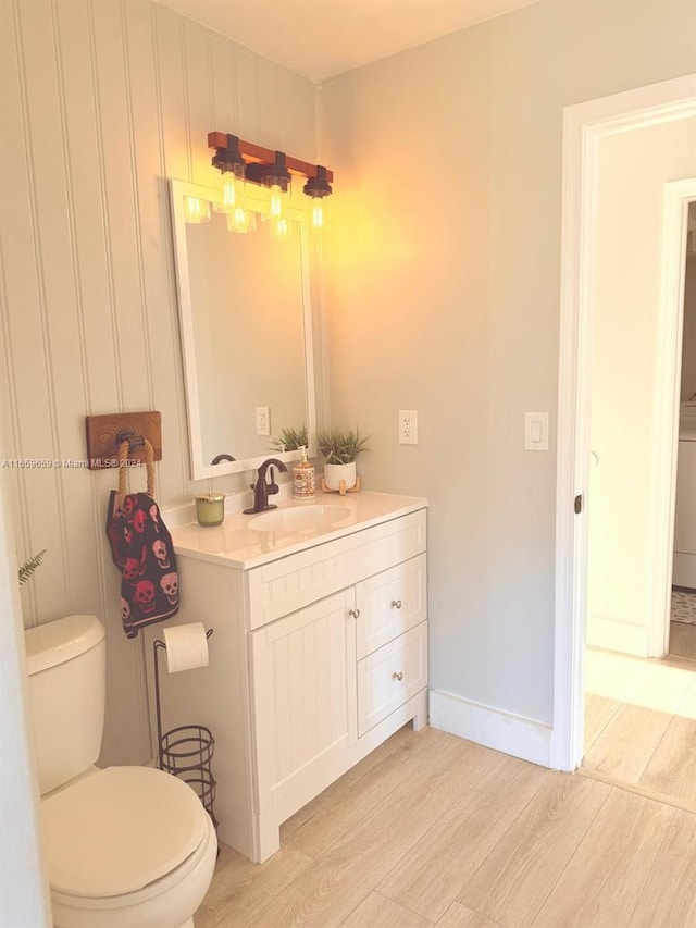 bathroom featuring toilet, vanity, and hardwood / wood-style flooring