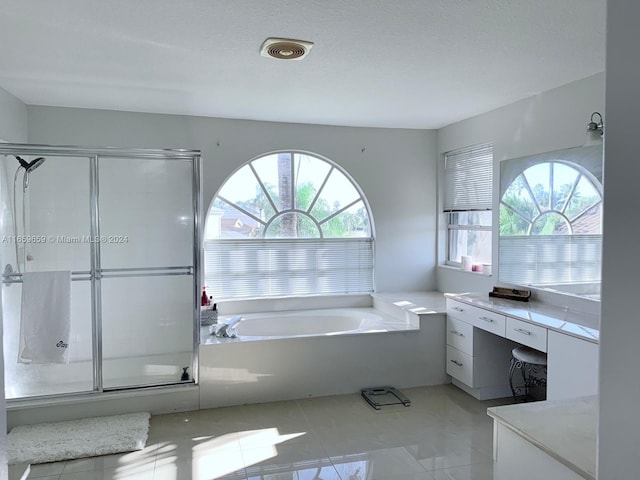 bathroom featuring a textured ceiling, separate shower and tub, and a healthy amount of sunlight