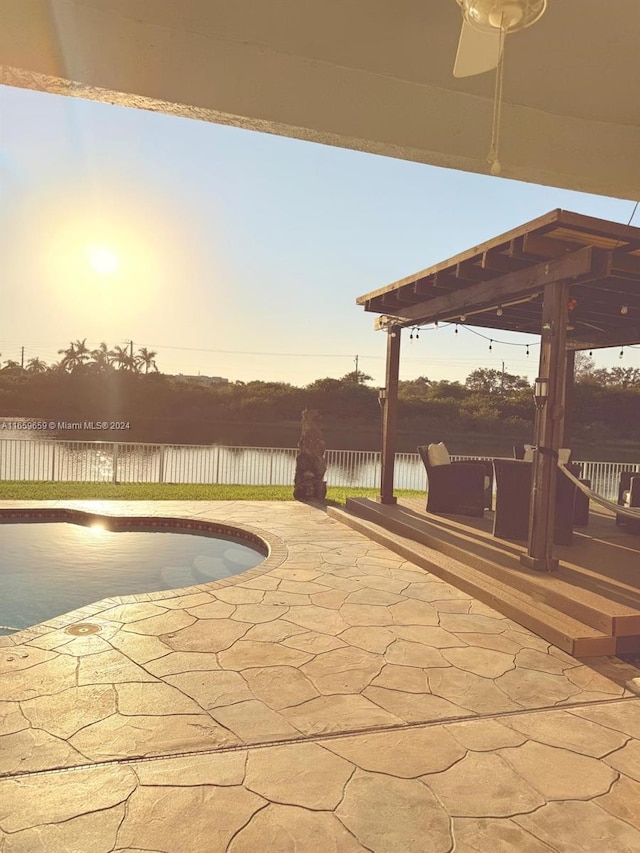 patio terrace at dusk featuring a fenced in pool