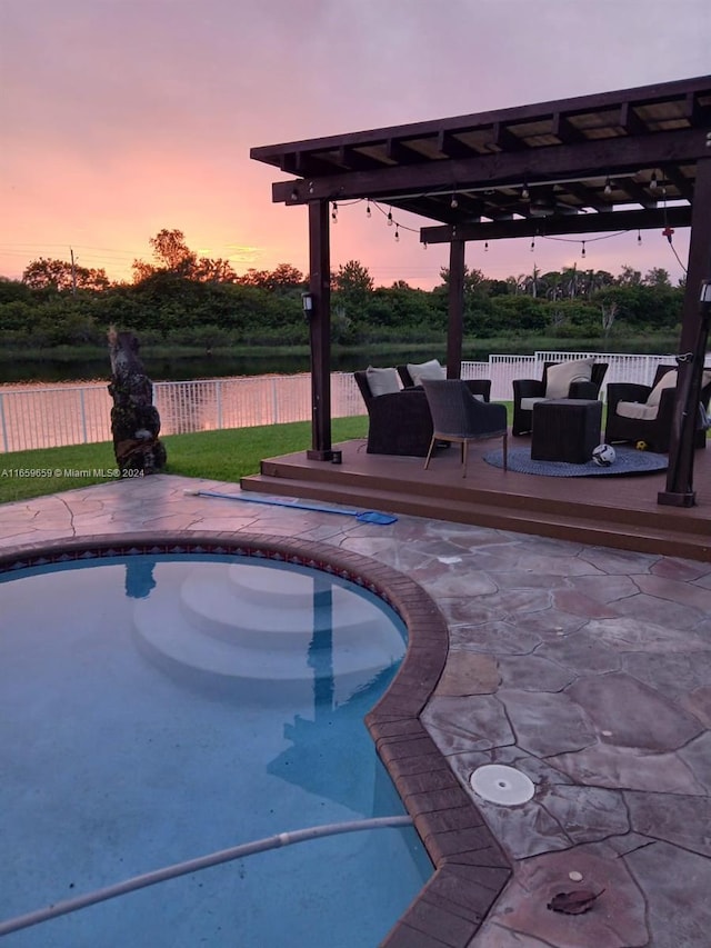 pool at dusk featuring outdoor lounge area, a deck, and a patio area