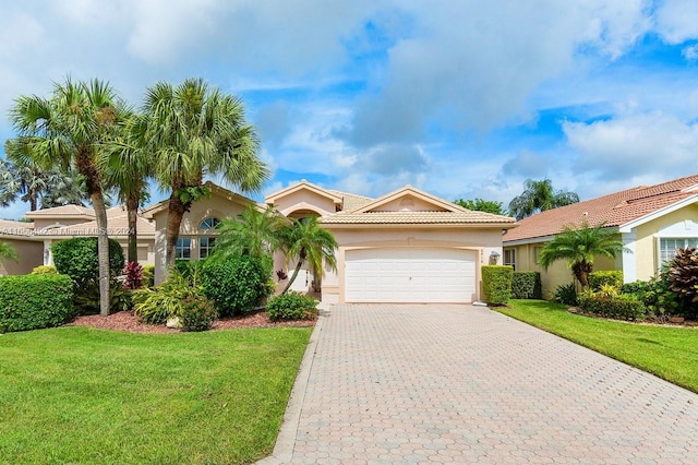 mediterranean / spanish-style house featuring a garage and a front yard