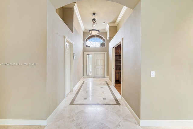 doorway to outside featuring a high ceiling and ornamental molding