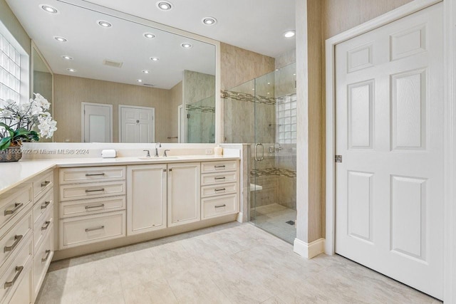 bathroom with a shower with door, vanity, and tile patterned floors