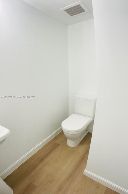 bathroom with hardwood / wood-style floors and toilet