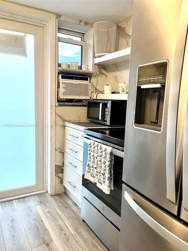 kitchen featuring stainless steel appliances, light hardwood / wood-style flooring, and white cabinets