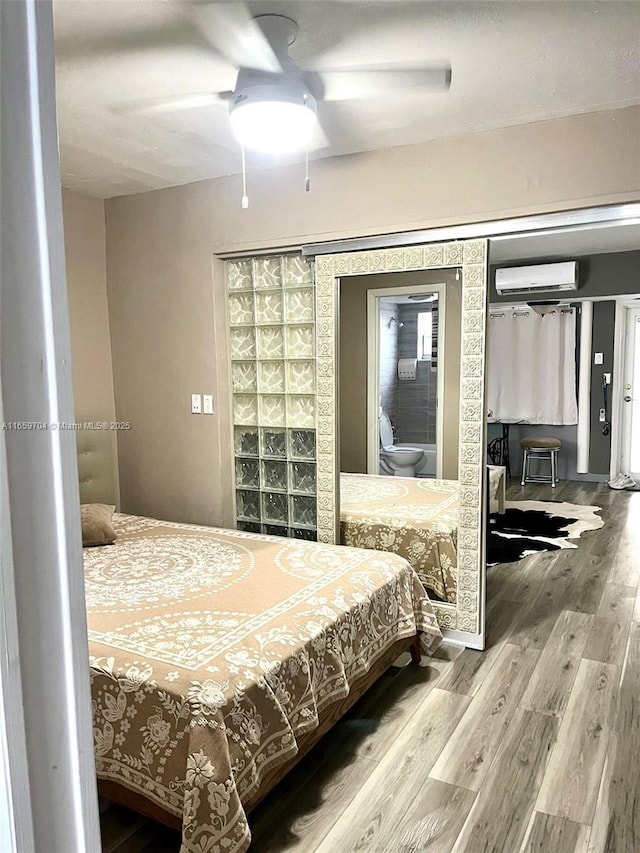 bedroom featuring hardwood / wood-style flooring, an AC wall unit, and ceiling fan