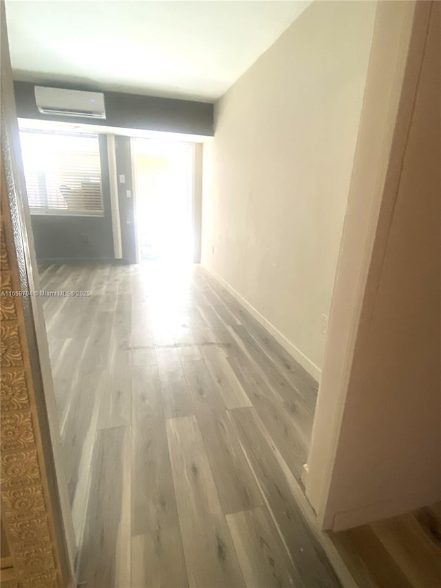 hallway featuring hardwood / wood-style flooring and a wall mounted air conditioner