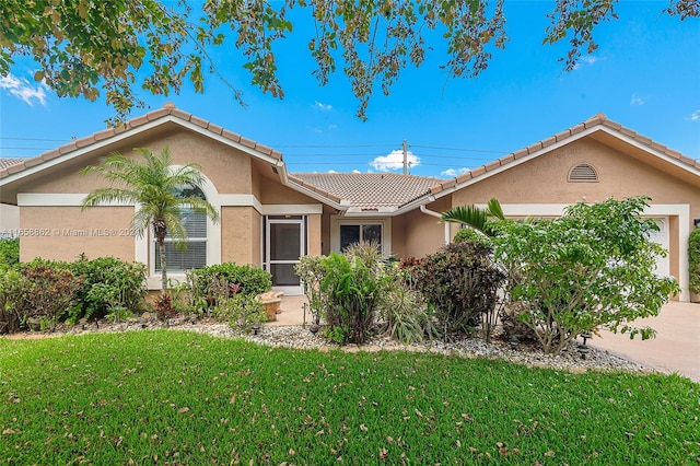 ranch-style home with a front yard and a garage