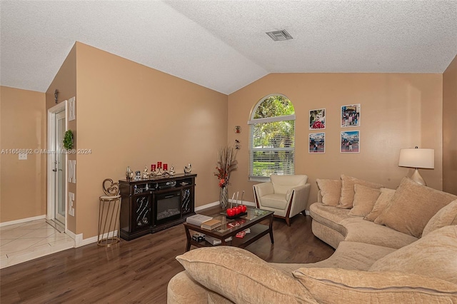 living room featuring a textured ceiling, vaulted ceiling, and wood-type flooring