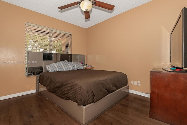 bedroom featuring a textured ceiling, ceiling fan, and dark hardwood / wood-style flooring