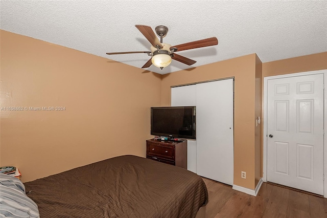 bedroom featuring ceiling fan, light hardwood / wood-style floors, and a textured ceiling