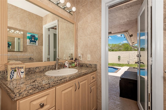 bathroom with vanity and tile walls