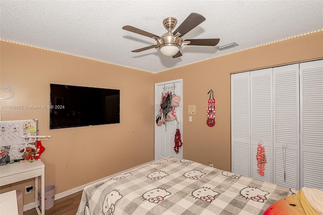 bedroom featuring a textured ceiling, hardwood / wood-style flooring, ceiling fan, and a closet