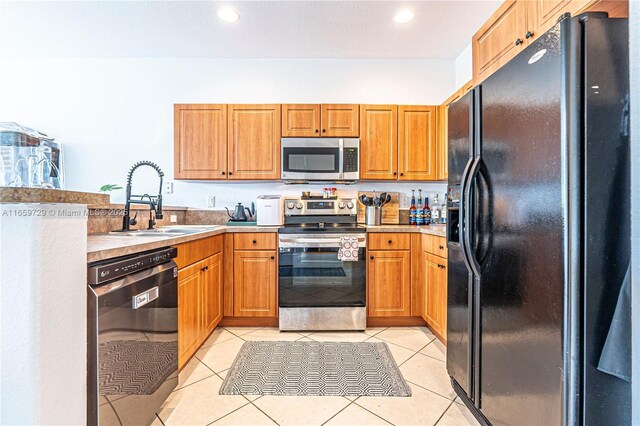 kitchen with sink, light tile patterned floors, and black appliances