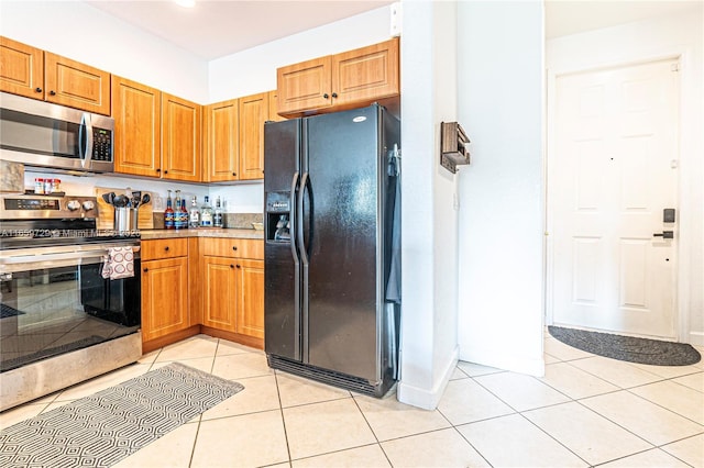 kitchen with light tile patterned flooring and appliances with stainless steel finishes