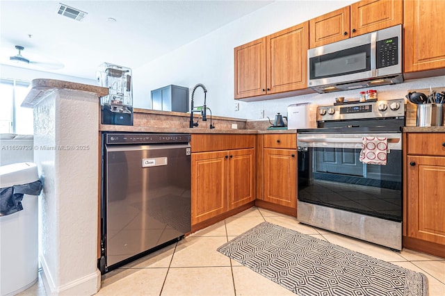 kitchen featuring light tile patterned flooring, appliances with stainless steel finishes, and sink