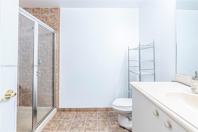 bathroom with tile patterned flooring, vanity, an enclosed shower, and toilet