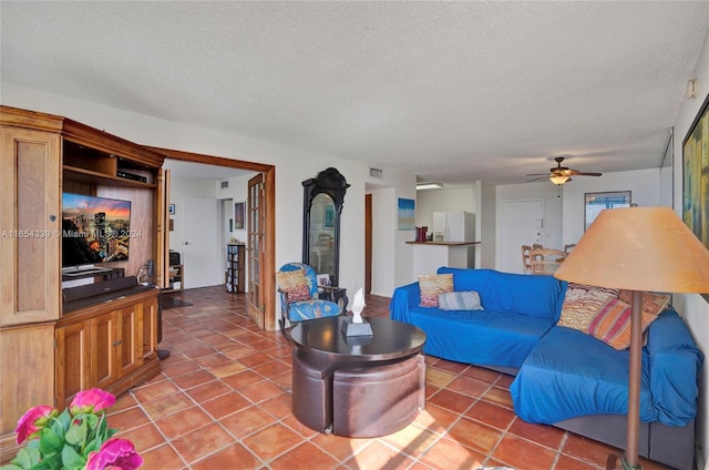 living room with tile patterned flooring, ceiling fan, and a textured ceiling